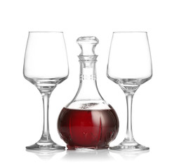Decanter of wine and glasses on white background