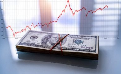 Profit from business with pile of American dollars. Focus on Frankiln. Man on hundred banknote
