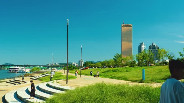 Time lapse shot of Seoul cityscape looking through Yeouido Hangang Park close to Han River in Seoul, South Korea
