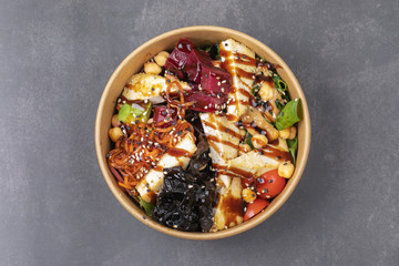 Vegan tofu poke bowls with seaweed, watermelon radish, cucumber, edamame beans and rice noodles.