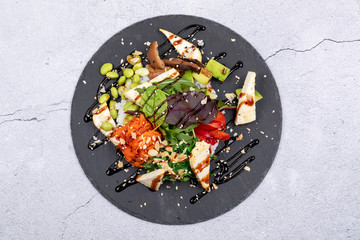 Vegan tofu poke bowls with seaweed, watermelon radish, cucumber, edamame beans and rice noodles.