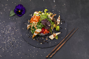 Vegan tofu poke bowls with seaweed, watermelon radish, cucumber, edamame beans and rice noodles.