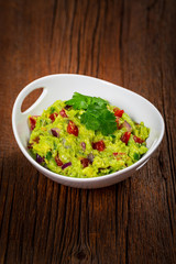 Avocado Guacamole Mexican Dip with Avocado, Lime, Tomato and Cilantro. Selective focus.