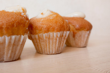 Muffin cakes dessert closeup view. Soft focus and blurred background of kitchen table. Homemade traditional baked food with morning coffee