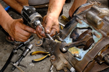 The motorcycle carburetor is waiting for maintenance and repair and the engine and mechanic check the engine.	