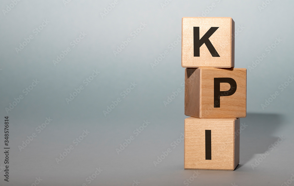 Poster acronym text kpi - key performance indicator. wooden cubes with letters isolated on gray background.