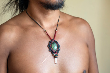 Male chest wearing elegant necklace with natural mineral gemstone