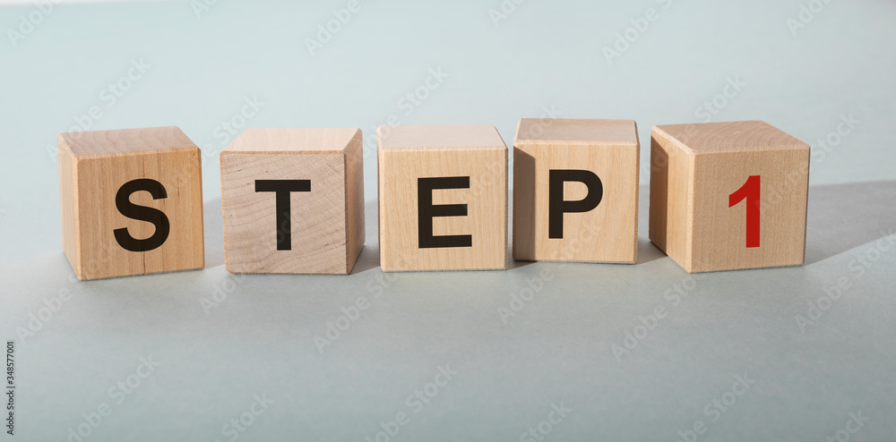 Poster step by step concept. step 1 one text on wooden cube blocks on blue grey table