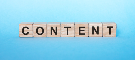 Content word text on wooden cube blocks on blue background. Digital marketing concept.