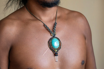 Male chest wearing elegant necklace with natural mineral gemstone