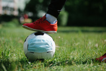 Foot and shoe with soccer football with face mask for sports during covid-19 pandemic