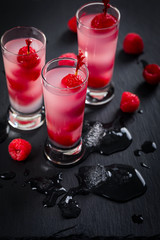 Raspberry Tequila Shots Cocktail with Fresh Raspberry on Black Background. Selective focus.