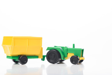 Toy green tractor yellow trailer isolated. Design element.