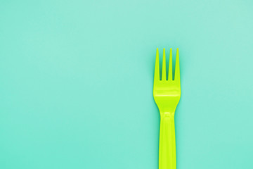 green fork on green background. eco food concept.