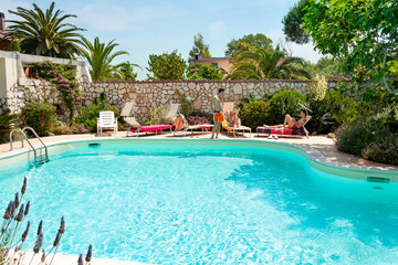 Men sunbathing beside the swimming pool