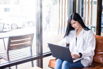 Asian businesswomen are using notebook computers and wear headphones for online meetings and working from home.