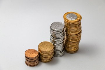 Moedas  do banco centra do Brasil empilhadas em fundo branco 
