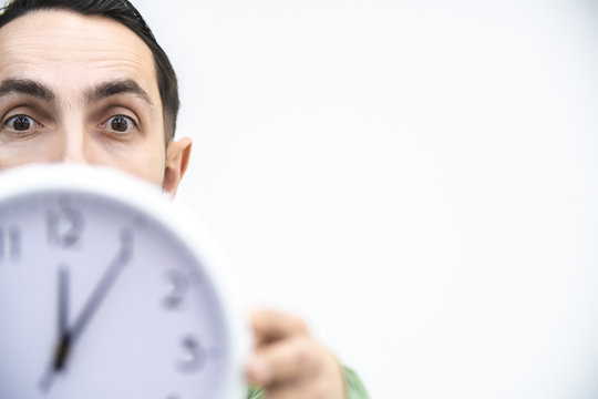 Cropped shot of businessman in a hurry, with clock in hands, trying to stop time, because a deadline is closer.