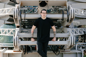 Handsome male model with beard wearing black blank t-shirt with free space for your logo or design in casual urban style