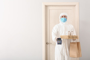 Courier of food delivery service in protective suit near customer's door. Concept of epidemic