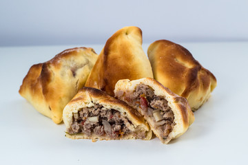 Brazilian snack. Meat Esfiha on white background.