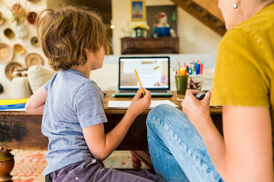 6 year old boy doing remote schooling on laptop computer at home