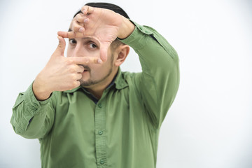 New view on business. Young man making frame with fis fingers and looking throung it.