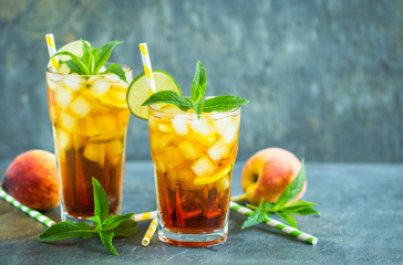  Homemade peach ice tea with ice, lime and mint in the glass 