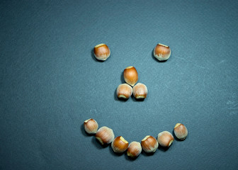 Emotions of joy, kindness, greetings. Smile. Dried fruits, hazelnuts. Black background.