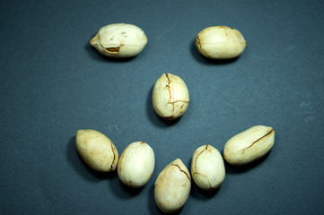 Emotions of joy, kindness, greetings. Smile. Dried fruits, Pecan nuts. Black background.