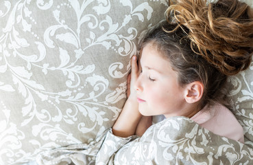 Kid sleeping in her parent's bed. Comfort concept.