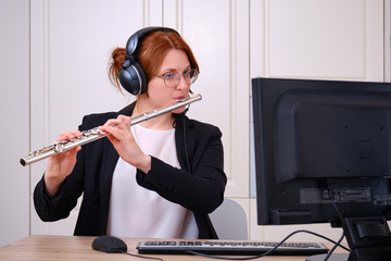 A music teacher conducts a lesson on playing a musical instrument over the Internet. Flute lessons...