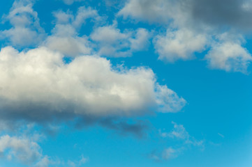 Background image of cumulus clouds on a blue evening sky.