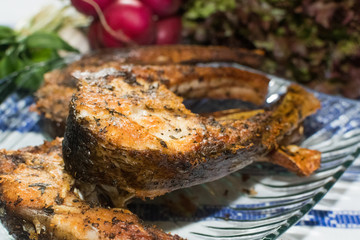 Freshly grilled fish on kitchen table. closeup, top view.