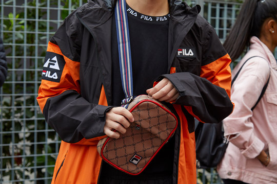 Man with black and orange Fila jacket and brown and red bag on September 22, 2019 in Milan, Italy