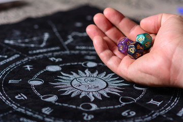 Tarot, future reading concept.  horoscope with zodiac signs and astrology dice like esoteric concept. Male Hand with  esoteric dices.