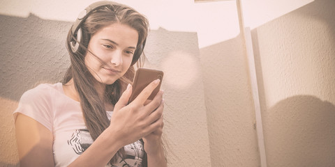 young beautiful girl listening music with smartphone in hands
