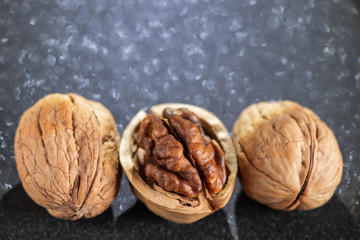 Three tasty walnuts with beautiful bokeh in the black background.