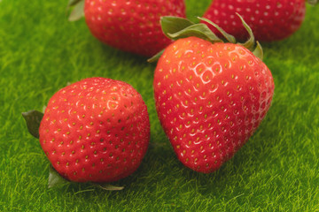 Juicy red strawberries as a symbol of summer on green grass