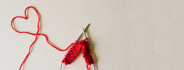 Knitting and thread shaped like a red heart on white background. Valentines day, love, heart concept