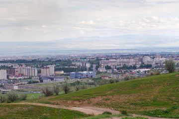 Fototapeta na wymiar View of the city from the mountain. Summer landscape. Kyrgyzstan, Bishkek
