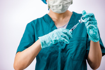 Female doctor with medical scrub holding syringe and vaccine. Healthcare And Medical concept on white background.