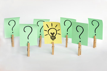 A lot of clothespins with question marks on stickers and on one light bulb, as a sign of a good idea.