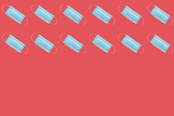 COVID-19 disposable surgical face mask on red background. Protection against coronavirus. Healthcare and medical concept. Seamless medical pattern with copyspace