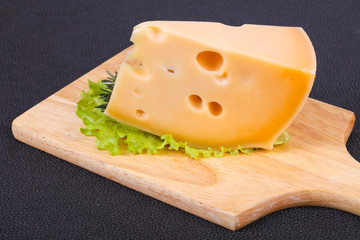Maasdam cheese  in the board served salad leaves