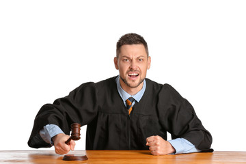 Angry male judge at table on white background