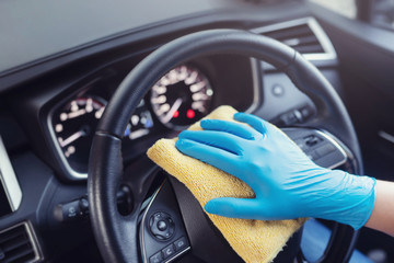car wash,  worker hand wear glove cleaning console steering wheel with microfiber cloth blue....