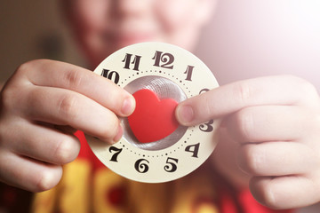 Watch with a red heart in children's hands