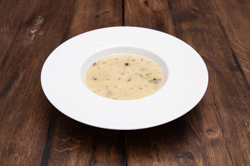 Cream soup with mushrooms and on wooden table. A plate of  Mushroom Cream-soup. 