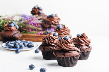 Homemade chocolate cupcakes on rustic wooden board